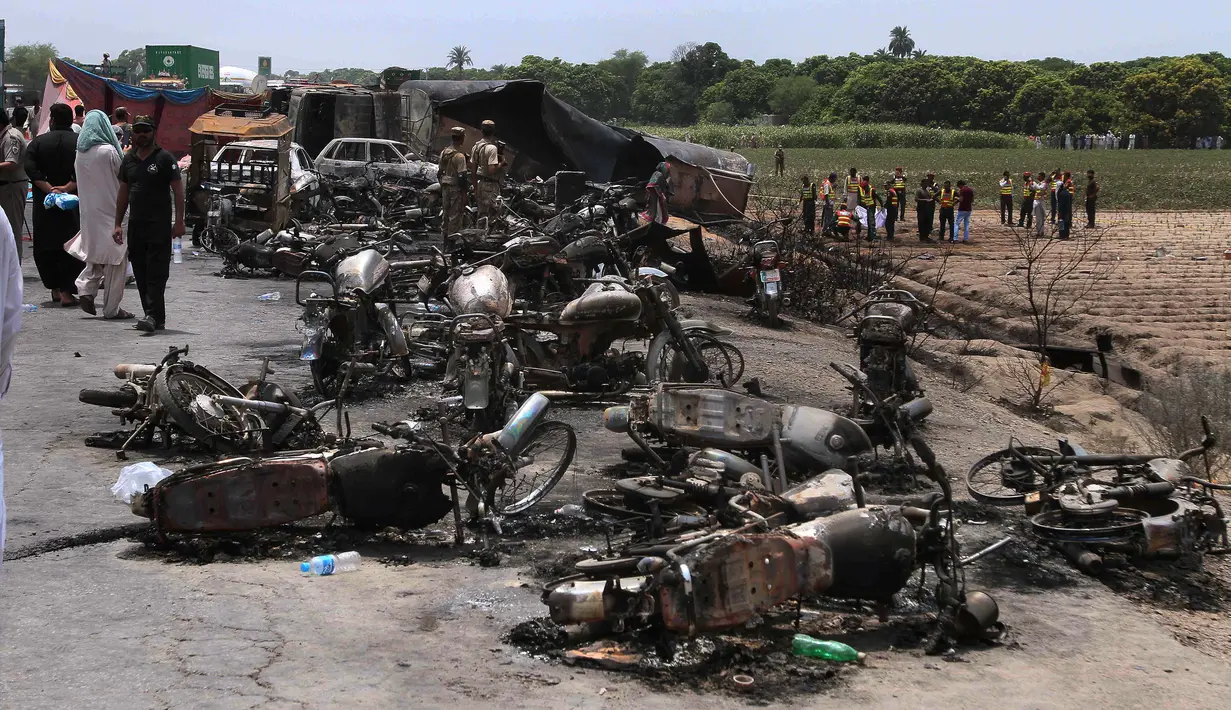 Sejumlah bangkai kendaraan yang hangus terbakar akibat ledakan truk tangki minyak yang terbalik dan meledak di jalan raya dekat Bahawalpur, Pakistan (25/6). Dikabarkan, sedikitnya 123 orang tewas dan 100 lainnya mengalami luka-luka. (AP Photo / Iram Asim)