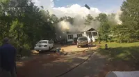 Sebuah kaleng aerosol terlihat terlempar dari dalam rumah dan terbang melejit hingga mengenai salah satu truk pemadam kebakaran.