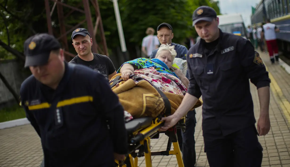 Seorang pasien dibawa dengan tandu untuk menaiki kereta evakuasi medis yang dijalankan oleh MSF (Doctors Without Borders) di stasiun kereta api di Pokrovsk, Ukraina timur, Minggu (29/5/2022). Kereta tersebut dilengkapi dikelola oleh tenaga medis, dan mengangkut pasien dari rumah sakit yang kewalahan di dekat garis depan, ke fasilitas medis di Ukraina barat, jauh dari pertempuran. (AP Photo/Francisco Seco)