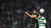 Pemain Real Madrid, Karim Benzema (kiri) bereduel udara dengan pemain Celtic, Josip Juranovic saat laga Grup F Liga Champions 2022/2023 antara Celtic melawan Real Madrid di stadion Celtic Park, Glasgow pada 6 September 2022. (AFP/Andy Buchanan)