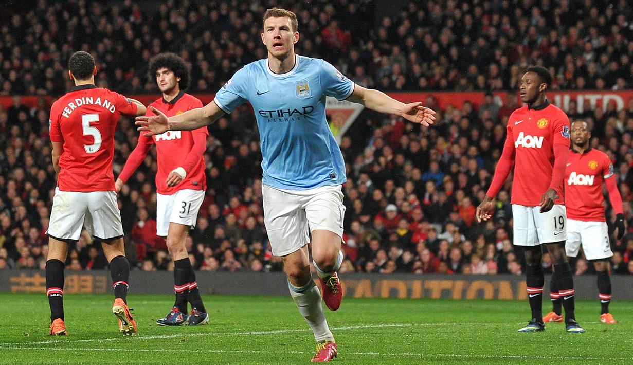 3-0. Kemenangan tiga gol tanpa balas Manchester City atas tuan rumah MU ini terjadi di pekan ke-28 Liga Inggris musim 2013/2014, 25 Maret 2014. Edin Dzeko menyumbang dua gol untuk Man City, satu gol lagi dicetak oleh Yaya Toure. (AFP/Paul Ellis)