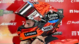 Sesi latihan bebas jelang MotoGP Indonesia 2025 di Sirkuit Internasional Mandalika, Mandalika, Nusa Tenggara Barat, digelar pada Jumat 3 Oktober 2025 pagi. Tampak dalam foto, pembalap MotoGP Spanyol dari Tim Ducati Lenovo, Marc Marquez mengenakan helmnya saat bersiap untuk sesi latihan bebas jelang Grand Prix MotoGP Indonesia di Sirkuit Internasional Mandalika, Nusa Tenggara Barat pada 3 Oktober 2025. (SONNY TUMBELAKA/AFP)