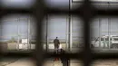 Seorang pria berdiri di pintu Friendship Park's yang ada di pagar perbatasan Amerika Serikat (AS) dengan Meksiko di Playas de Tijuana, Baja California, Meksiko, Minggu (11/3). (GUILLERMO ARIAS/AFP)