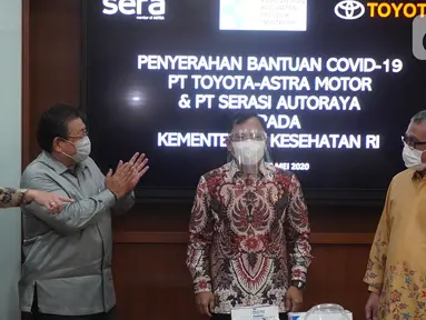 Menteri Kesehatan Terawan Agus Putranto (kedua kanan) disaksikan Presdir PT Toyota Astra Motor (TAM) Susumu Matsuda (kedua kiri) saat mencoba face shield yang merupakan bantuan dari TAM dan PT Serasi Autoraya (SERA) untuk penanganan Covid-19 di Jakarta Rabu (20/5/2020). (Liputan6.com/HO/Ady)