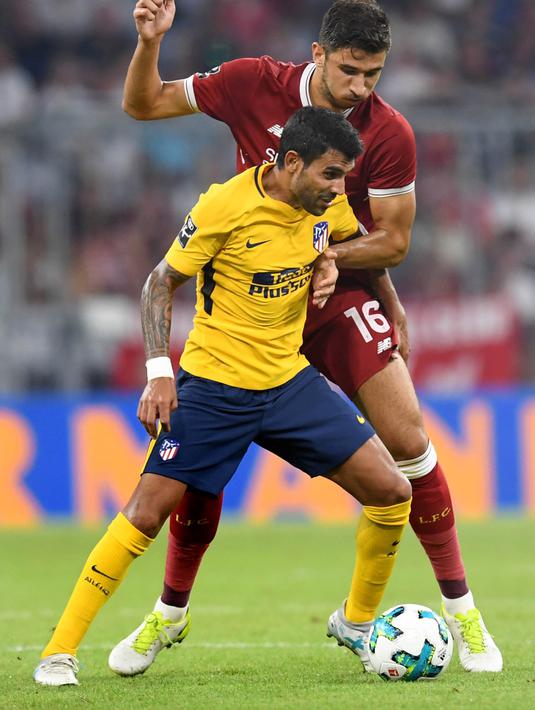 Gelandang Liverpool, Marko Grujic, berebut bola dengan gelandang Atletico Madrid, Augusto, pada laga final Audi Cup di Stadion Allianz, Munchen, Rabu (2/8/2017). Atletico Madrid menang 5-4 atas Liverpool melalui adu penalti. (AFP/Christof Stache)