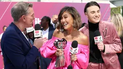 Penyanyi Agnez Mo (tengah) memegang piala iHeartRadio Music Awards 2019 di Los Angeles, California, AS, Kamis (14/3). Agnez Mo mengalahkan Bhad Bhabie, Joji, Lele Pons, Queen Naija hingga Trixie Mattel. (Phillip Faraone/Getty Images North America/AFP)