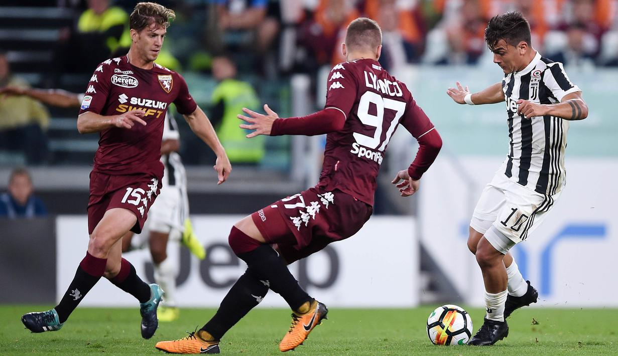 Striker Juventus, Paulo Dybala, berusaha melewati pemain Torino pada laga Serie A, Italia, di Stadion Allianz, Sabtu (23/9/2017). Juventus menang 4-0 atas Torino. (AFP/Filippo Monteforte)