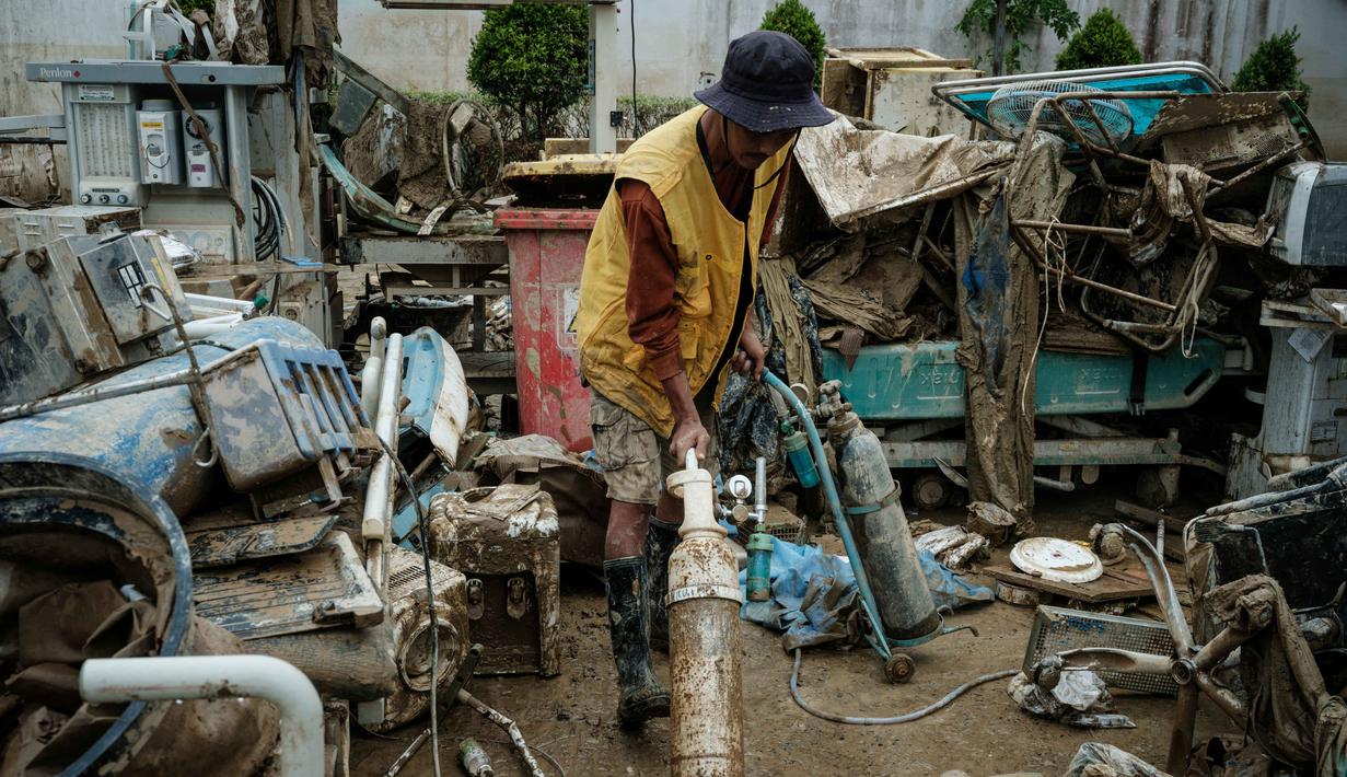 Pembersihan ini guna mempercepat kembalinya aktivitas pelayanan kesehatan kepada masyarakat, khususnya korban banjir bandang. Tampak dalam foto, seorang pekerja. membersihkan peralatan medis yang terendam air setelah banjir bandang sekitar tiga bulan lalu di Rumah Sakit Daerah Aceh Tamiang, pada Selasa 16 Desember 2025. (Yasuyoshi Chiba/AFP)