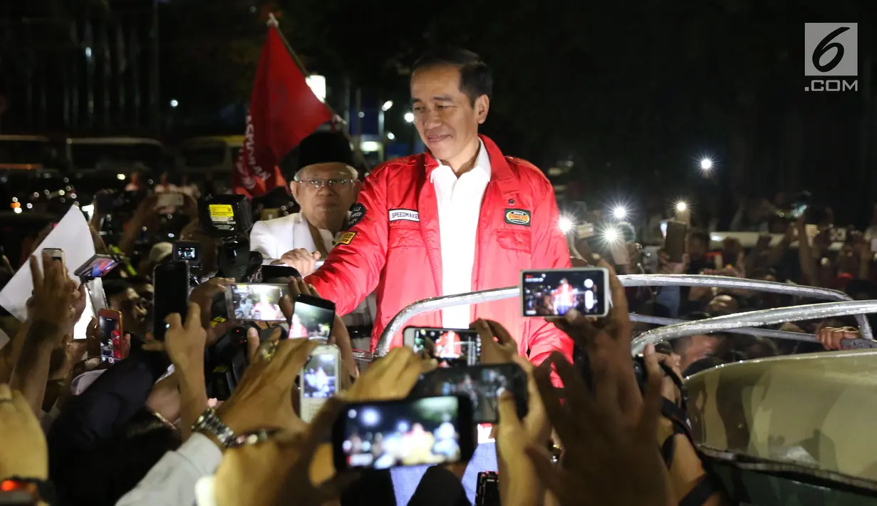 Calon Presiden RI Petahana, Joko Widodo bersama Cawapres Ma’ruf Amin menyapa pendukungnya saat berada di atas jeep menuju gedung KPU dari Tugu Proklamasi, Jakarta, Jumat (21/9). (Liputan6.com/Helmi Fithriansyah)