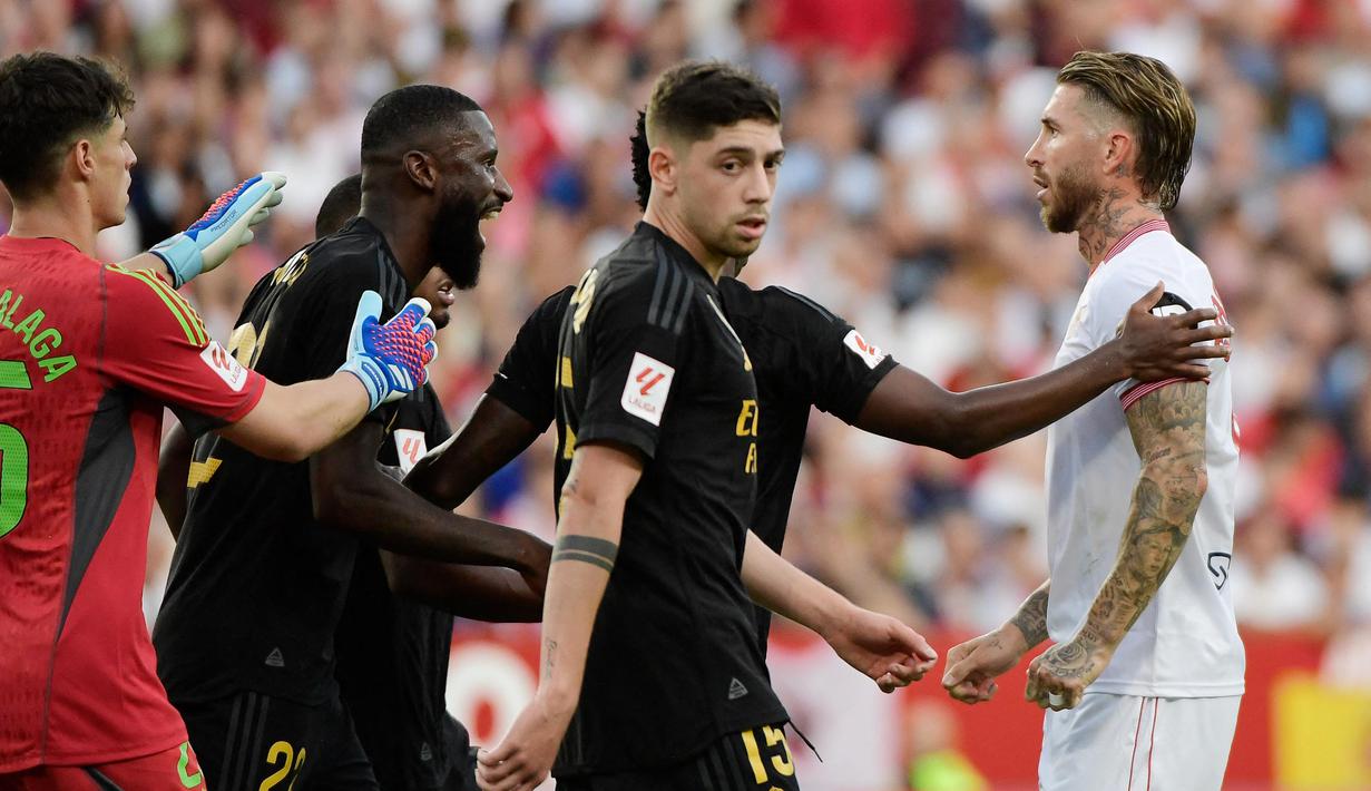 Pemain Sevilla, Sergio Ramos, bersitegang dengan pemain Real Madrid, Antonio Rudiger, pada laga Liga Spanyol di Stadion Ramon Sanchez Pizjuan, Sabtu (21/10/2023). (AFP/Crsitina Quicler)