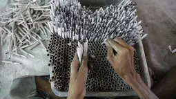 Pekerja membuat petasan untuk festival Hindu Diwali yang akan datang di Ahmedabad, India, 28 Oktober 2020. Pihak berwenang sedang mempersiapkan diri menghadapi gelombang baru Covid-19, setelah Diwali, festival keagamaan terpenting di negara itu, akan digelar pada 14 November. (AP/Ajit Solanki)