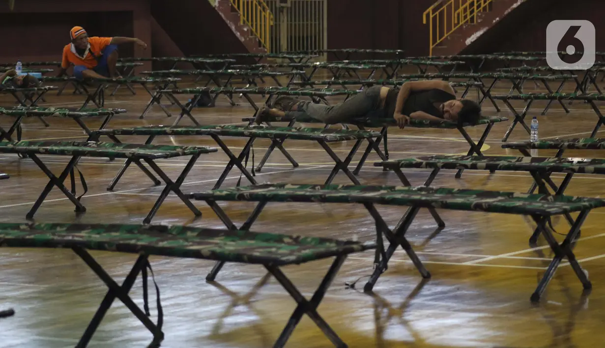 Para tunawisma beristirahat di GOR Ciracas, Jakarta, Selasa (28/4/2020). Untuk mencegah meluasnya virus Covid-19, Pemprov DKI Jakarta menyiapkan seluruh GOR di Jakarta untuk menampung tunawisma, salah satunya GOR Ciracas dengan kapasitas 100 tempat tidur. (Liputan6.com/Helmi Fithriansyah)