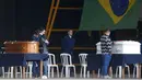 Kerabat korban kecelakaan pesawat Voepass berduka di samping peti mati mereka dalam sebuah misa di pangkalan udara Sao Paulo di Guarulhos, Brasil, Selasa (13/8/2024). (Miguel SCHINCARIOL / AFP)