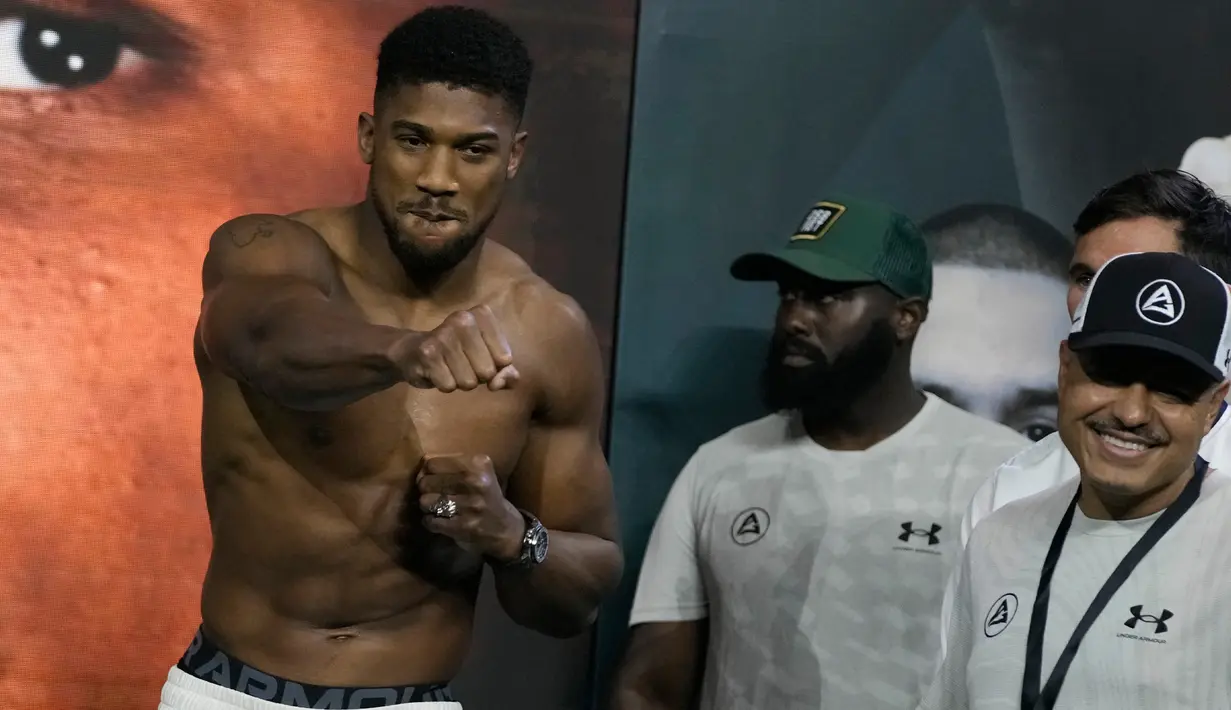 Petinju Inggris Anthony Joshua (kiri) memberi isyarat saat penimbangan di King Abdullah Sports City, Jeddah, Arab Saudi, 19 Agustus 2022. Joshua dijadwalkan melawan juara bertahan Usyk dalam pertandingan ulang tinju kelas berat di Jeddah pada 20 Agustus. (AP Photo/Hassan Ammar)
