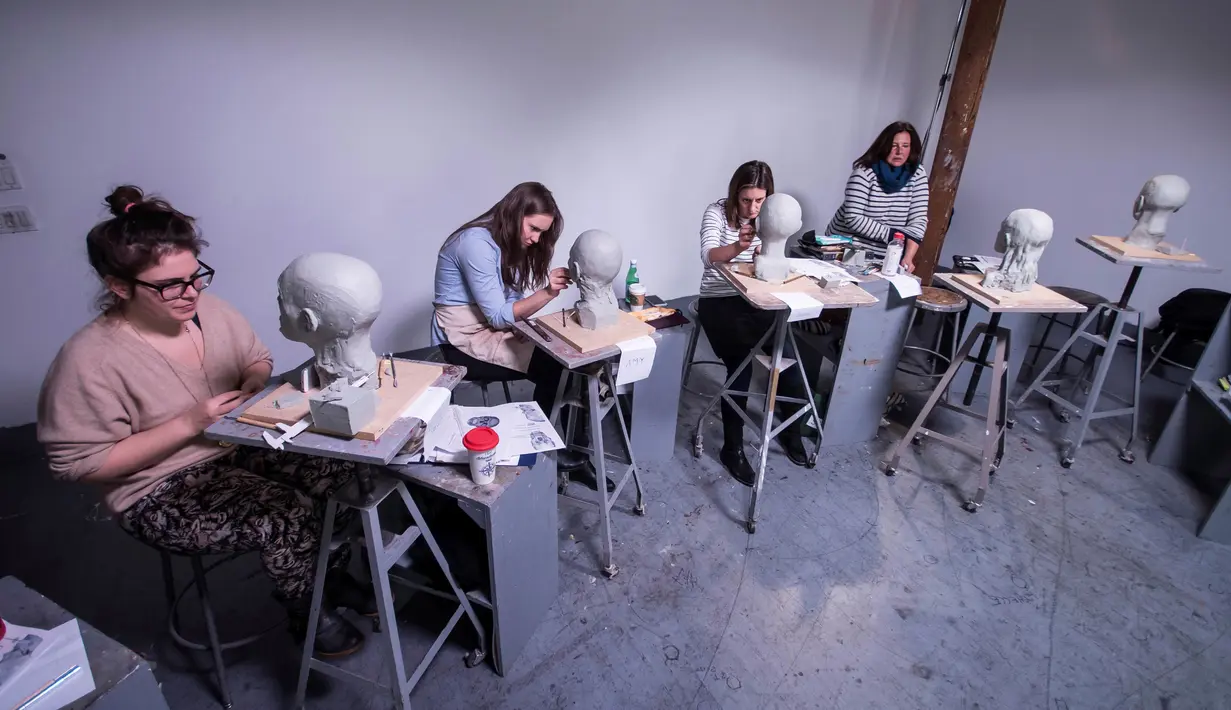 Sejumlah siswa terlihat serius menciptakan wajah orang mati dari tanah liat di New York, AS pada  bulan Januari 2016. Patung dibuat dengan harapan dapat menemukan identitas orang yang mati. (Courtesy the New York Academy of Art/Handout via REUTERS)
