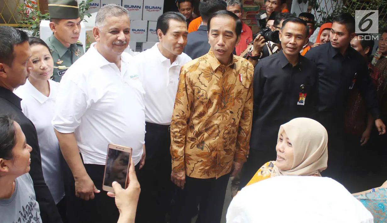 Presiden Joko Widodo (Jokowi) didampingi Menteri BUMN Rini Soemarno dan Dirut Bank BRI Suprajarto menyaksikan pembagian 200 paket Ramadan yang berisi sembako kepada warga di wilayah Penjaringan, Jakarta Utara, Selasa (13/6). (Liputan6.com/Angga Yuniar)