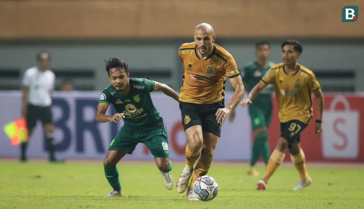 Pemain Bhayangkara FC, Youssef Ezzejjari Lhasnaoui (tengah) berusaha melepaskan diri dari pemain Persebaya Surabaya, Muhammad Hidayat saat laga pekan ketiga BRI Liga 1 2022/2023 antara Bhayangkara FC melaran Persebaya Surabaya di Stadion Wibawa Mukti, Cikarang, Minggu (07/08/2022). (Bola.com/Bagaskara Lazuardi)