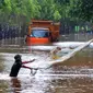 Warga menjala ikan di tengah jalan yang tertutup banjir di kawasan TB Simatupang, Jakarta Selatan, Sabtu (20/2/2021). Banjir terjadi akibat luapan Kali Serua yang berada di pinggir jalan tol. (merdeka.com/Arie Basuki)