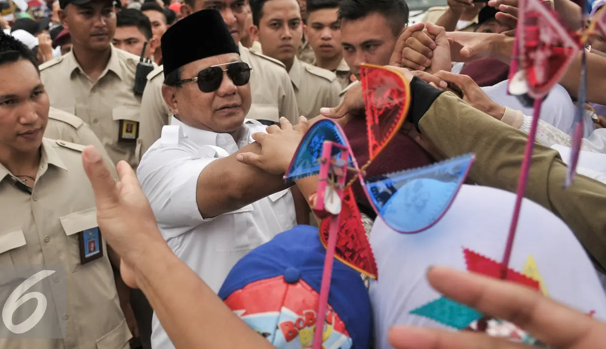 Massa pendukung Cagub dan Cawagub Anies-Sandi berebut untuk bersalaman dengan Prabowo Subianto di Lapangan Banteng, Jakarta, Minggu (5/2). (Liputan6.com/Yoppy Renato)