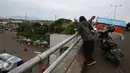 Pengendara sepeda motor menepikan kendaraannya di atas jalan layang Pasar Rebo, Jakarta, Sabtu (14/1). Padahal aktivitas tersebut berbahaya bagi keselamatan mereka serta pengendara lain. (Liputan6.com/Immanuel Antonius)