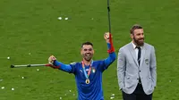 Pemain Italia Leonardo Spinazzola (kiri) dan asisten pelatih Daniele De Rossi usai mengalahkan Inggris pada pertandingan final Euro 2020 di Stadion Wembley, London, Inggris, 11 Juli 2021. Bek kiri ini menjadi motor serangan Italia. (FACUNDO ARRIZABALAGA/POOL/AFP)
