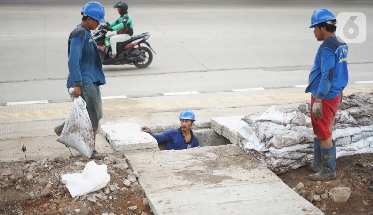 Petugas membersihkan saluran gorong-gorong air di Jalan DI Panjaitan, Kebon Nanas, Jakarta, Jumat (6/12/2019). Hal tersebut dilakukan guna mengantisipasi tersumbatnya saluran air selama memasuki periode musim hujan. (Liputan6.com/Immanuel Antonius)