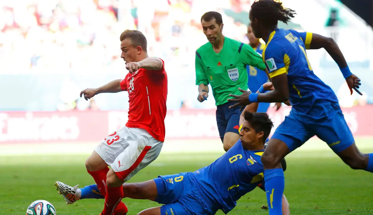Gelandang Timnas Swiss, Xherdan Shaqiri (kiri) dijegal pemain tengah Ekuador, Cristian Noboa saat berlaga di penyisihan Piala Dunia 2014 Grup E di Estádio Nacional de Brasilia, (15/6/2014). (REUTERS/Paul Hanna)