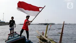 Seorang anak mengibar-ngibarkan bendera Merah Putih usai pelaksanaan Upacara Peringatan HUT RI ke-77 di Kawasan Kalibaru Barat, Cilincing, Jakarta, Rabu (17/8/2022). Memperingati Hari Kemerdekaan Indonesia ke-77, anak-anak yang tergabung dalam Kelas Jurnalis Cilik bersama para relawan melaksanakan upacara bendera dan beragam lomba. (Liputan6.com/Helmi Fithriansyah)