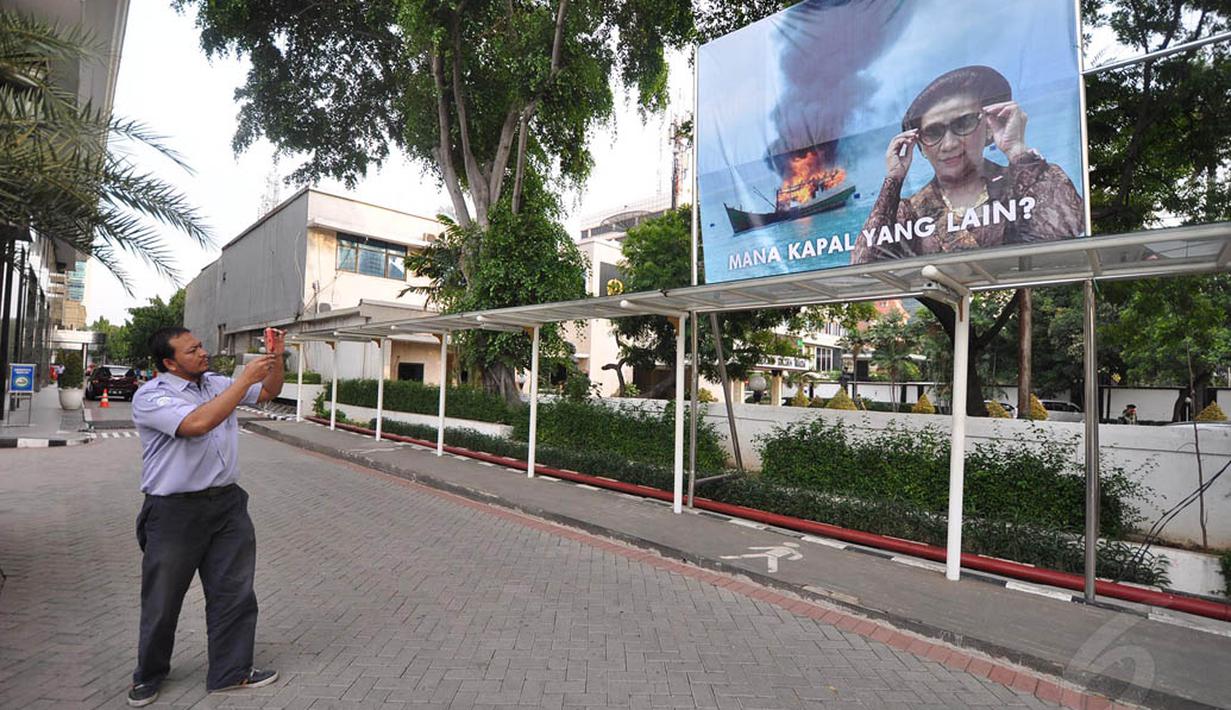 Seorang pegawai tampak mengambil gambar 'meme' yang sebelumnya ramai beredar di jejaring sosial. Foto diambil pada Kamis (11/12/2014). (Liputan6.com/Miftahul Hayat)