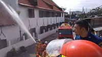 Petugas pemadam kebakaran berusaha memadamkan kobaran api yang melanda Museum Bahari di Penjaringan, Jakarta Utara, Selasa (16/1). Api mengamuk di Gedung C, yang berlokasi di bagian belakang museum. (Liputan6.com/Istimewa)
