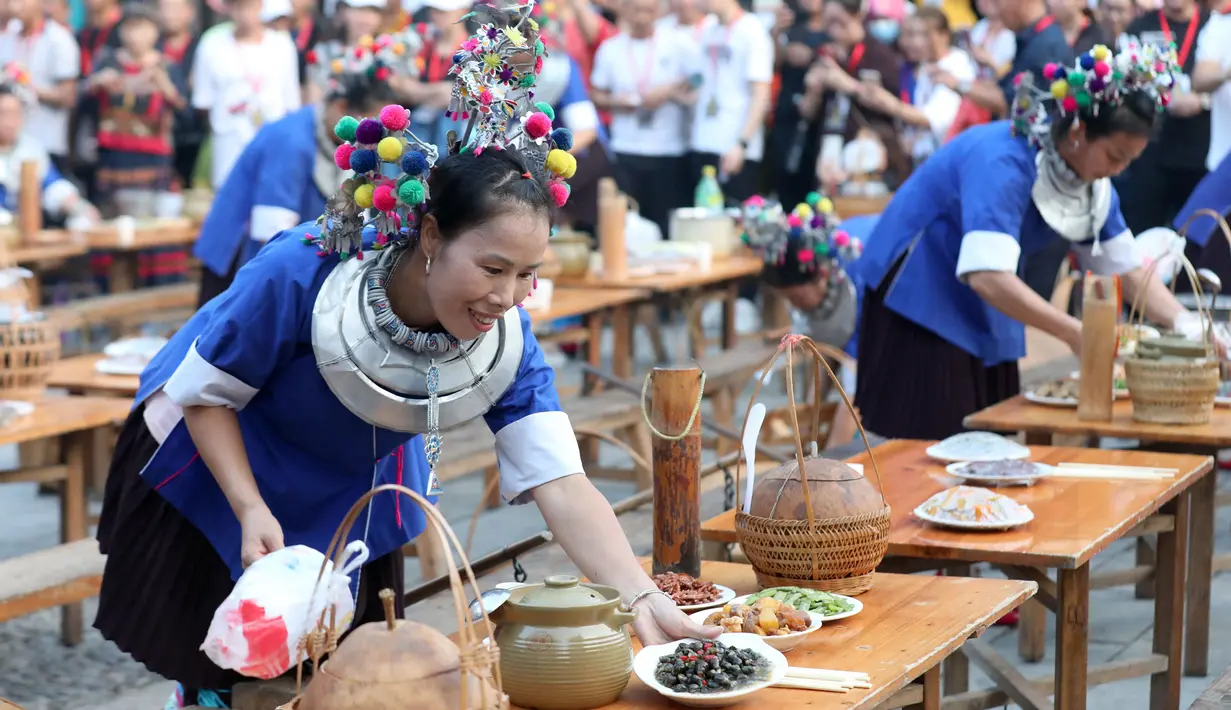 Warga lokal menyiapkan sajian untuk para wisatawan di sebuah kawasan wisata di Wilayah Otonom Etnis Dong Sanjiang di Kota Liuzhou, China, 2 Oktober 2020. Sejak jalur kereta cepat Guiyang-Guangzhou beroperasi, Sanjiang telah berupaya meningkatkan perekonomian melalui pariwisata. (Xinhua/Gong Pukang)