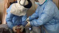 Pekerja medis memompa oksigen kepada pasien virus corona atau COVID-19 di sebuah rumah sakit di Wuhan, Provinsi Hubei, China, Minggu (16/2/2020). Sebanyak 1.770 orang dilaporkan meninggal akibat virus corona. (Chinatopix via AP)