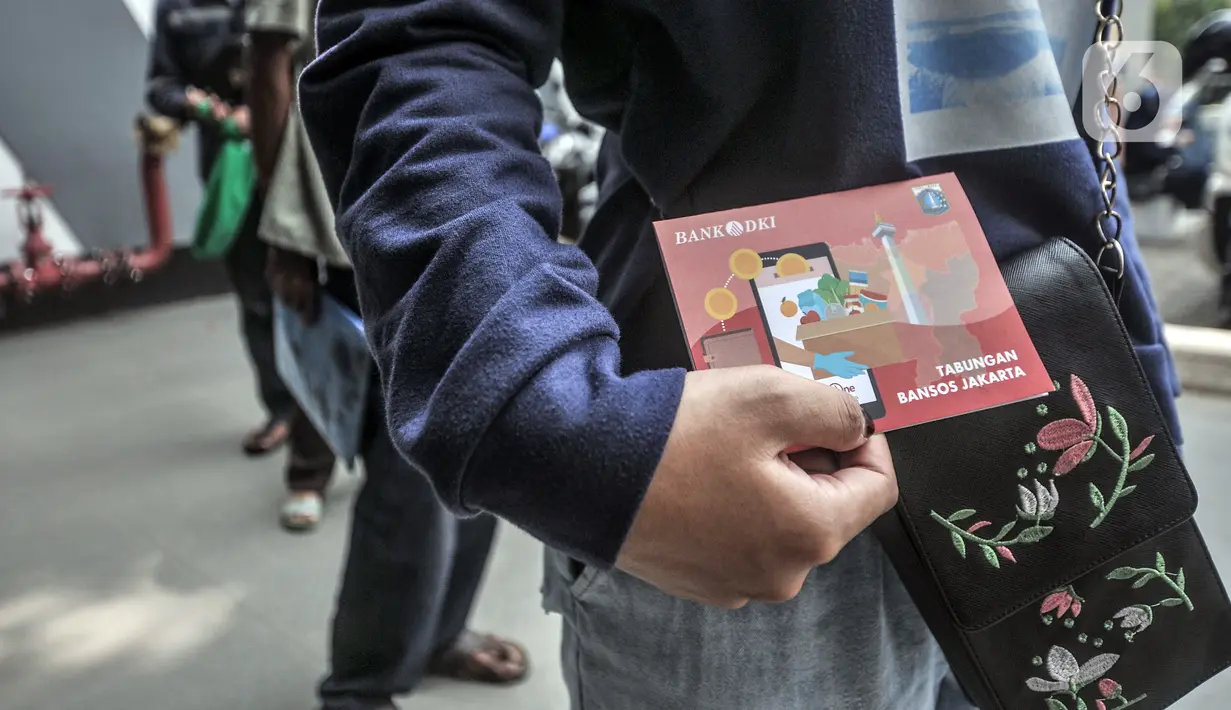 Warga membawa buku tabungan saat antre untuk mencairkan dana bantuan sosial tunai (BST) di ATM Bank DKI kawasan Matraman, Jakarta, Rabu (21/7/2021). BST disalurkan melalui rekening Bank DKI sebesar Rp 600 ribu per KK yang merupakan rapelan bulan Mei dan Juni. (merdeka.com/Iqbal S. Nugroho)