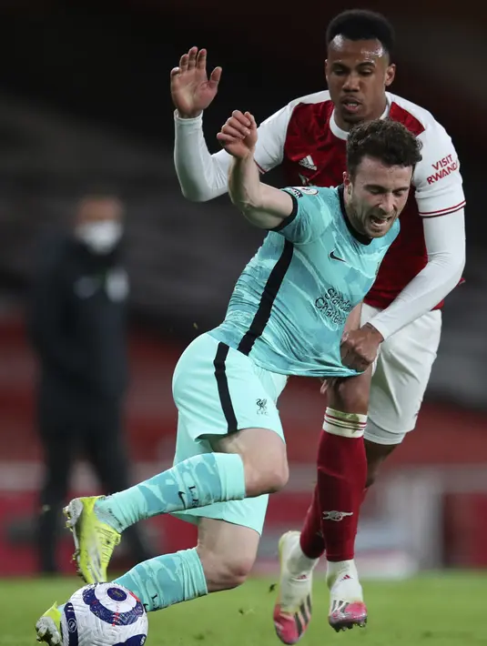 Pemain Arsenal Gabriel (kiri) memperebutkan bola dengan pemain Liverpool Diogo Jota pada pertandingan Liga Inggris di Emirates Stadium, London, Inggris, Sabtu (3/4/2021). Liverpool membantai Arsenal dengan skor 3-0. (Catherine Ivill/Pool via AP)