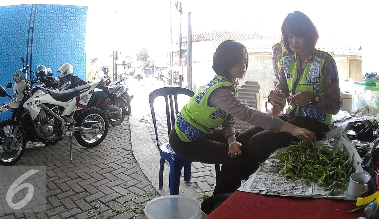Para Polwan mempersiapkan bahan makanan di pos pengamanan 06 exit tol Brebes Timur, Jawa Tengah, Sabtu (9/7). Anggota Satlantas Polres Brebes sedang mempersiapkan makanan siang untuk anggota kepolisian yang sedang bertugas. (Liputan6.com/Herman Zakharia)