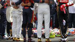 Para pebalap F1 meletakkan helm di tengah lingkaran saat mengheningkan cipta selama satu menit sebelum memulai balapan. (Reuters/Laszlo Balogh)