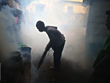 Petugas melakukan fogging di kawasan padat penduduk di Kebon Nanas, Jakarta, Jumat (15/4). Fogging tersebut dilakukan untuk mencegah berkembangbiaknya nyamuk aedes aegypti penyebab penyakit demam berdarah dengue. (Liputan6.com/Immanuel Antonius)