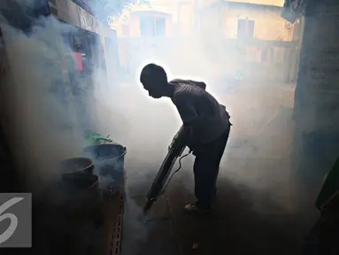 Petugas melakukan fogging di kawasan padat penduduk di Kebon Nanas, Jakarta, Jumat (15/4). Fogging tersebut dilakukan untuk mencegah berkembangbiaknya nyamuk aedes aegypti penyebab penyakit demam berdarah dengue. (Liputan6.com/Immanuel Antonius)