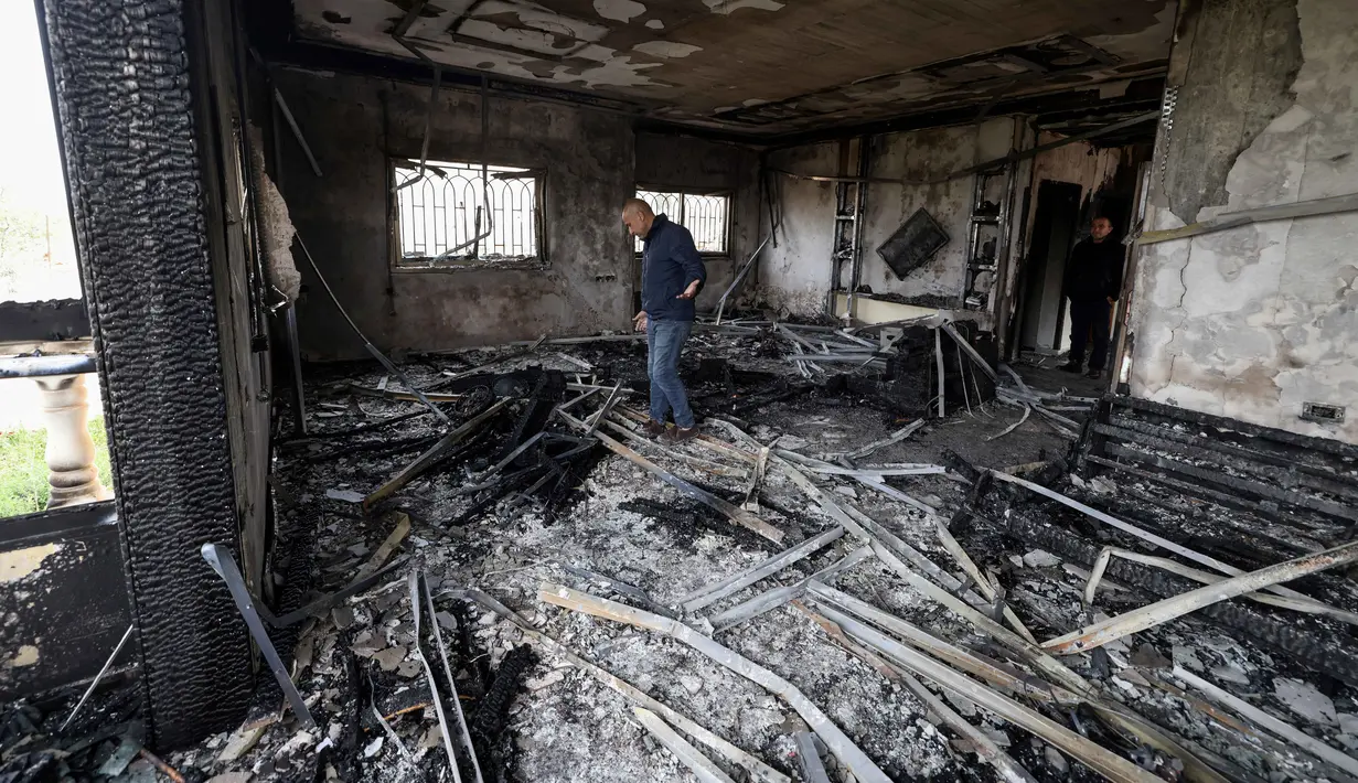 Serangan ini terjadi di tengah meningkatnya ketegangan selama libur Idulfitri dan menyusul eskalasi konflik regional yang lebih luas. Tampak dalam foto, seorang pria Palestina memeriksa sisa-sisa rumah yang terbakar setelah serangan yang dilaporkan dilakukan oleh pemukim Israel di desa Deir al-Hatab, sebelah timur kota Nablus, di Tepi Barat, wilayah yang diduduki Israel pada Senin 23 Maret 2026. (JAAFAR ASHTIYEH/AFP)