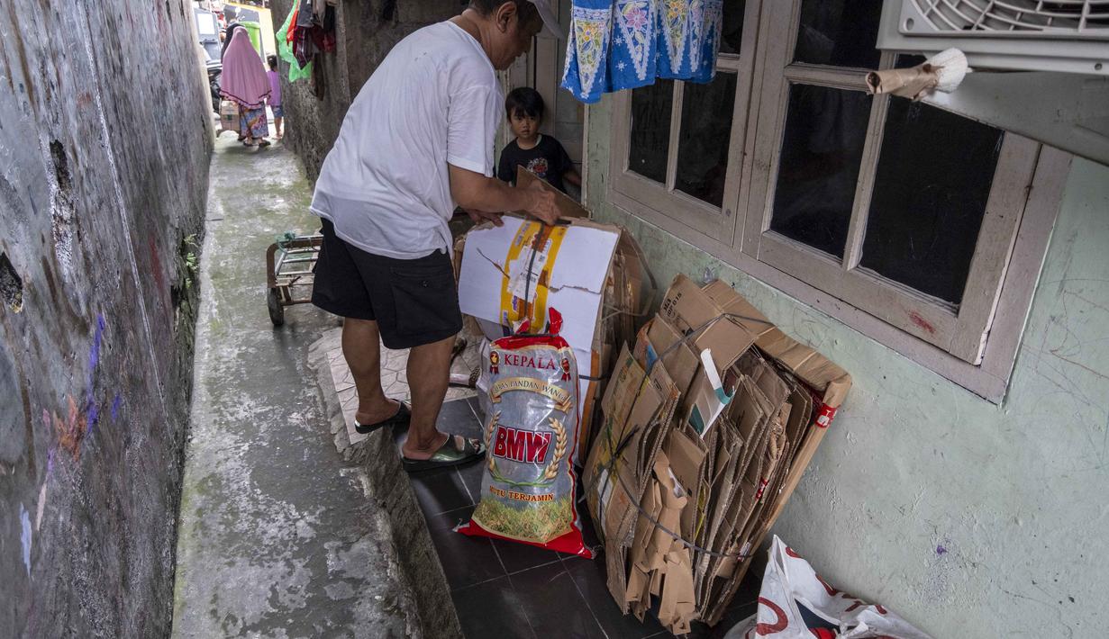 Seorang pria menyiapkan sampah rumah tangga anorganik, berupa kardus dan botol plastik, untuk disetorkan ke bank sampah setempat, Jakarta, Kamis 4 Juni 2026, sebagai bagian dari instruksi Pemprov DKI yang mewajibkan warga memilih dan memilah sampah untuk mengurangi beban sampah yang semakin menumpuk di ibu kota. (BAY ISMOYO/AFP)
