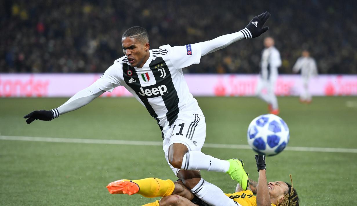 Bek Juventus  Alex Sandro gagal melewati hadangan pemain Young Boys pada laga lanjutan Liga Champions yang berlangsung di stadion Stade de Suisse, Swiss, Kamis (13/12). Juventus kalah 1-2 atas Young Boys. (AFP/Fabrice Coffrini)