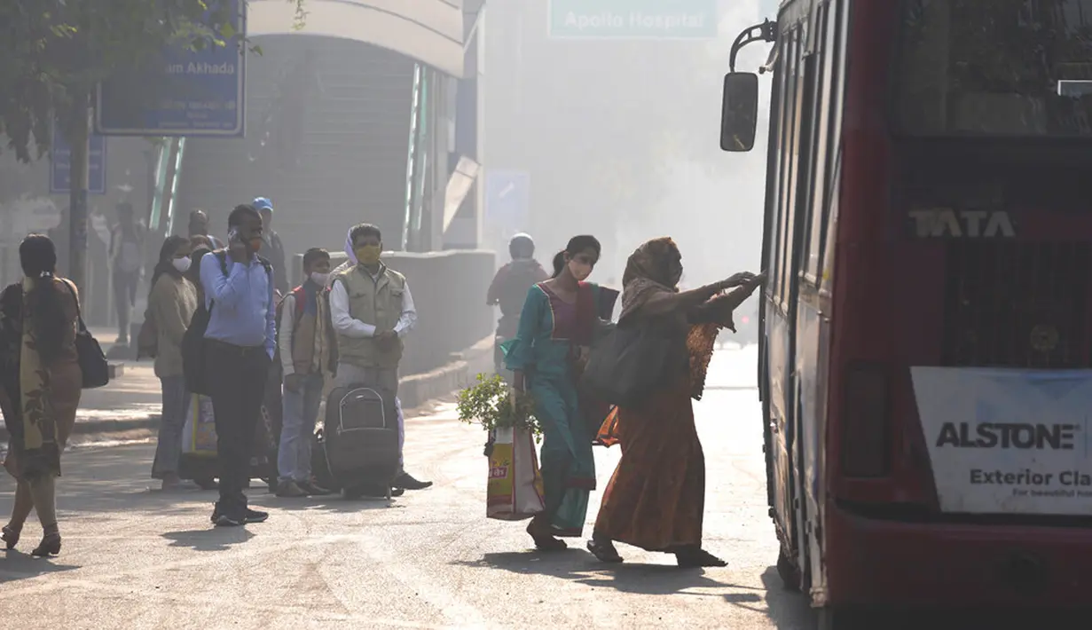 Para komuter menaiki transportasi lokal di tengah kabut pagi dan kabut asap beracun di New Delhi, India, 17 November 2021. New Delhi merupakan kota yang kerap diselimuti kabut asap musim dingin parah tiap tahun. (AP Photo/Manish Swarup)