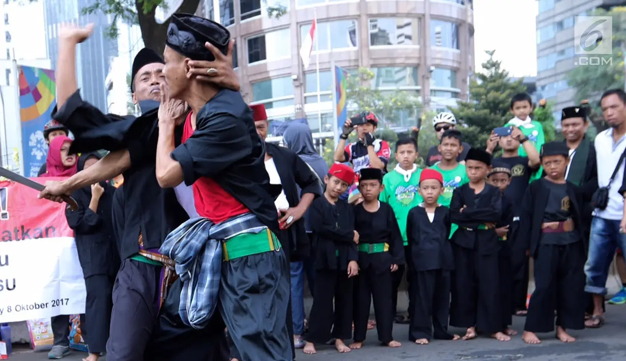 Seorang pendekar silat menangkis pukulan lawannya ketika memperagakan jurus beladiri saat Car Free Day di kawasan Senayan, Jakarta, Minggu (8/10). Aksi yang tergabung dalam Dewan Kesehatan Rakyat ini untuk memeriahkan CFD. (Liputan6.com/Fery Pradolo)