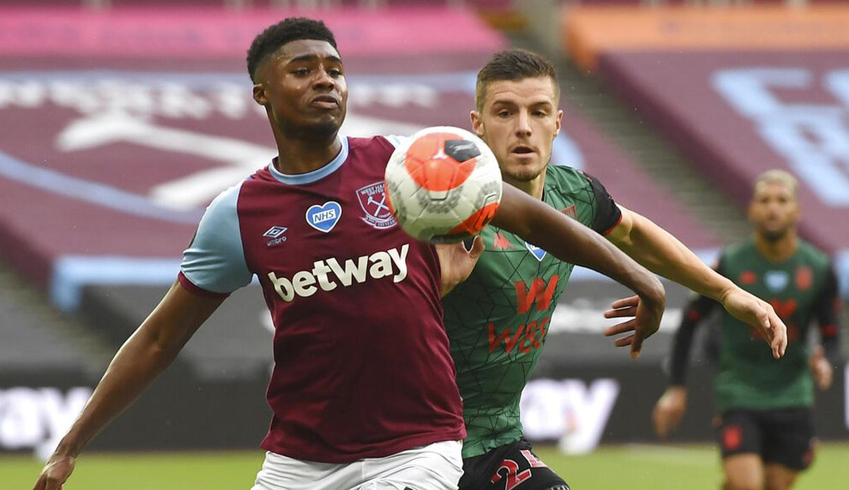 Pemain Aston Villa, Frederic Guilbert, berebut bola dengan pemain West Ham United, Ben Johnson, pada laga Premier League di Stadion London, Minggu (26/7/2020). Kedua tim bermain imbang 1-1. (Andy Rain/Pool via AP)