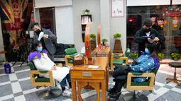 Sejumlah warga mencukur rambut di sebuah tempat cukur rambut di wilayah Xiushan, Chongqing, China barat daya, Jumat (27/2/2020). Kegiatan produksi dan kehidupan sehari-hari warga berangsur normal berkat upaya pengendalian virus corona COVID-19 yang efektif di Xiushan. (Xinhua/Liu Chan)