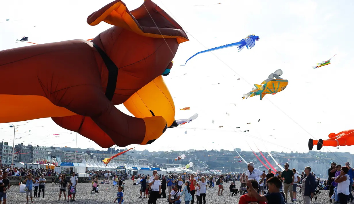 Orang-orang menerbangkan layang-layang selama Festival Layang-layang Internasional Dieppe ke-20 di Dieppe, Prancis, Minggu (9/9). Acara yang diadakan hingga 16 September ini mengumpulkan ribuan orang dari 34 negara. (AFP/CHARLY TRIBALLEAU)