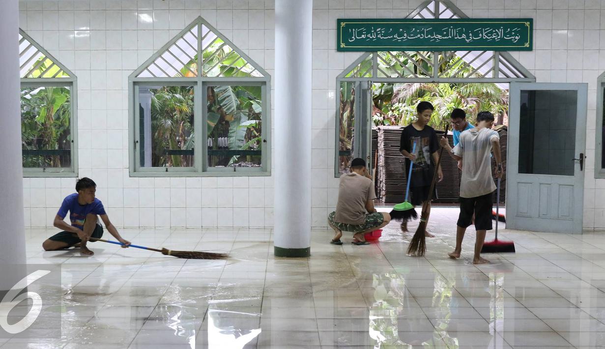 Warga bergotong royong mengeluarkan air saat banjir menggenangi Mesjid An Nur di kawasan Pasar Minggu, Jakarta, (4/10). Banjir yang rutin menggenangi kawasan tersebut menyebabkan aktivitas warga serta ibadah terganggu. (Liputan6.com/Immanuel Antonius)