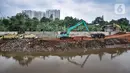 Pekerja menggunakan kendaraan alat berat saat menyelesaikan proyek Normalisasi Sungai Ciliwung di kawasan Cawang, Kramat Jati, Jakarta Timur, Rabu (7/12/2022). Dinas Sumber Daya Air (SDA) DKI Jakarta dan DPRD DKI Jakarta sepakat menganggarkan Rp469,29 miliar untuk program Normalisasi Sungai Ciliwung dalam APBD 2023. (merdeka.com/Iqbal S. Nugroho)