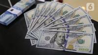 Karyawan bank menunjukkan mata uang dolar Amerika Serikat (AS) di Jakarta, Senin (2/11/2020). Nilai tukar rupiah pada perdagangan Senin (2/11) sore ditutup melemah 0,1 persen ke level Rp14.640 per dolar AS, dari perdagangan sebelumnya yaitu Rp14.690 per dolar AS. (Liputan6.com/Angga Yuniar)