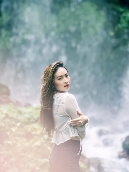 Aktris yang satu ini mengenakan kemeja putih agak tembus pandang. Matanya tajam menatap kamera. [Instagram @natashawilona12]